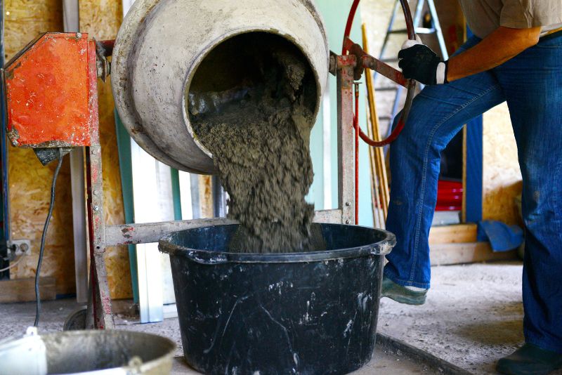 pouring concrete from the mixer to the bucket